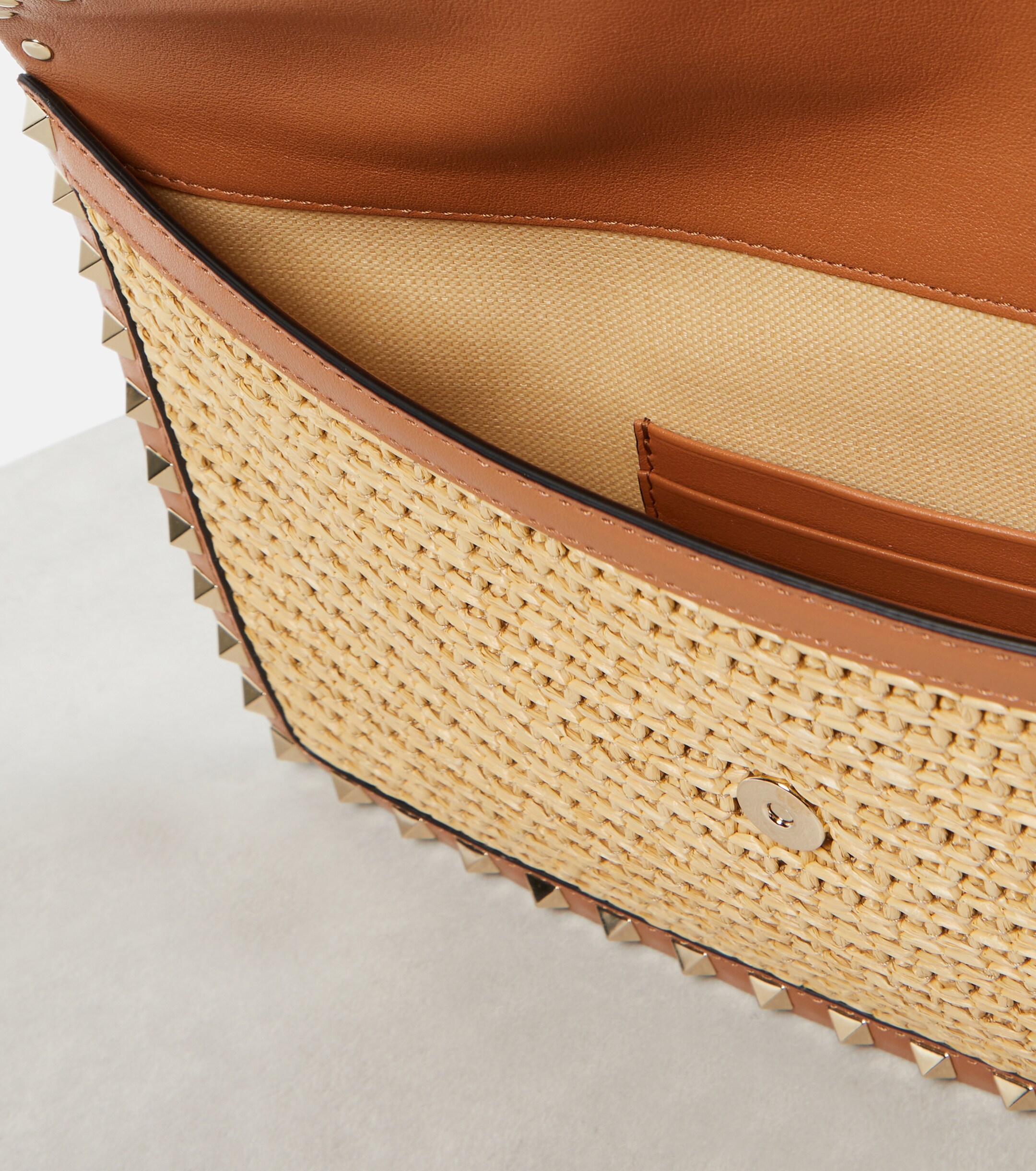 Valentino Garavani Rockstud Large leather-trimmed raffia clutch thumbnail